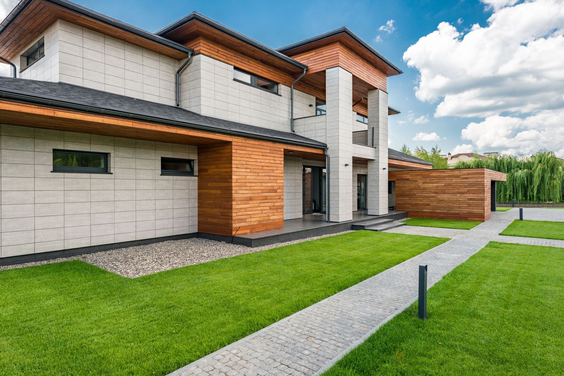 A modern wood-and-stone custom home in daylight